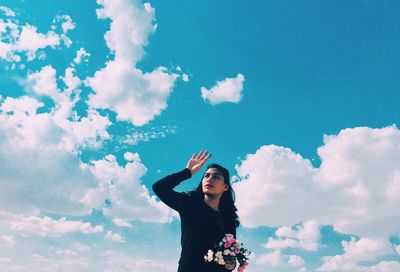 Low angle view of woman standing against sky