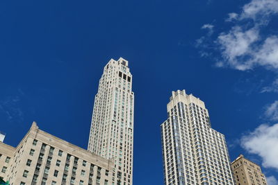 Low angle view of modern buildings against blue sky
