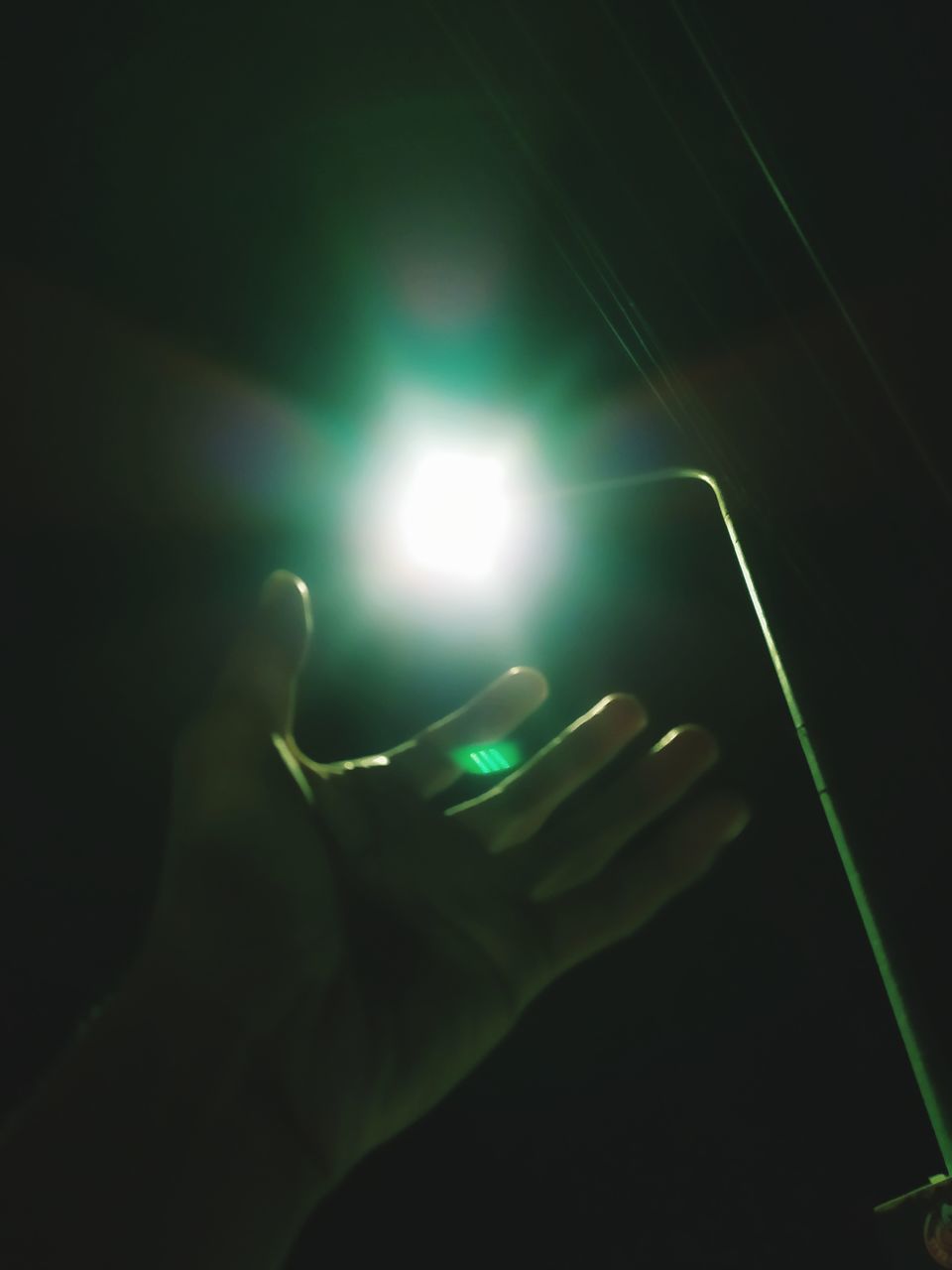 hand, light, green, darkness, one person, holding, illuminated, lighting, light - natural phenomenon, finger, indoors, lighting equipment, technology, glowing, night, adult, lens flare, close-up