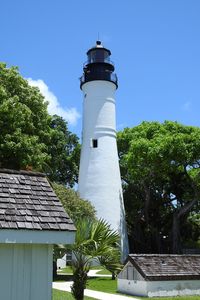 Low angle view of lighthouse by building against sky