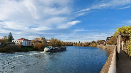 Scenic view of river by buildings against sky