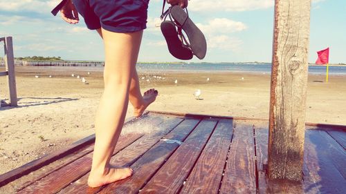 Low section of woman standing on beach