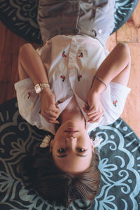 Portrait of young woman lying on bed