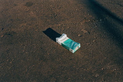 High angle view of abandoned bottle on wet road