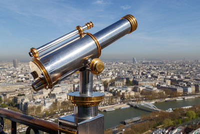 Close-up of coin-operated binoculars against cityscape