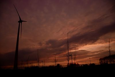 Low angle view of electricity pylon against cloudy sky