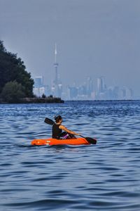 Woman on boat in sea against sky