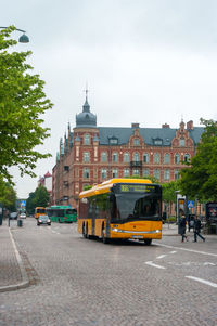Cars on city street against sky