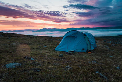 Midnight sun and storm cloud with fog inversion from mountain tent site in arctic sweden