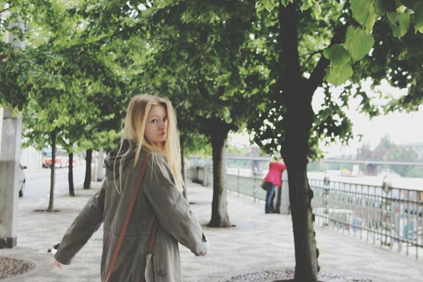 tree, lifestyles, leisure activity, full length, casual clothing, tree trunk, focus on foreground, walking, person, day, young adult, incidental people, park - man made space, outdoors, standing, front view, young women