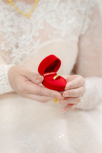 Midsection of woman holding heart shape