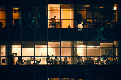Group of people in glass building at night