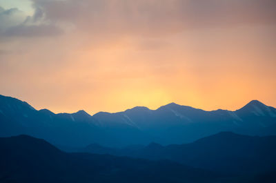 Scenic view of silhouette mountains against sky during sunset