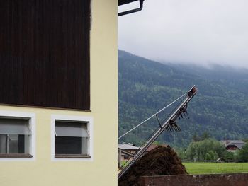 Building by mountains against sky