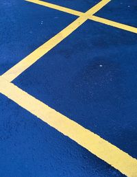High angle view of yellow lines on blue parking lot