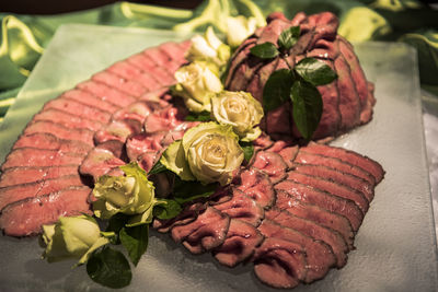 Close-up of meat with roses on table