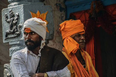 Men looking away while standing outdoors