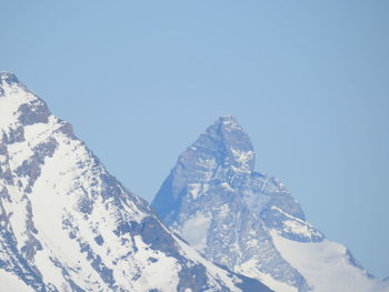 Scenic view of snowcapped mountains against clear blue sky