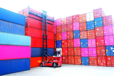 Stack of multi colored building at harbor against sky