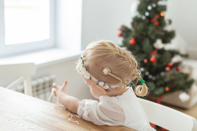 Side view of girl playing with teddy bear at home