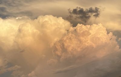 Low angle view of sunlight streaming through clouds