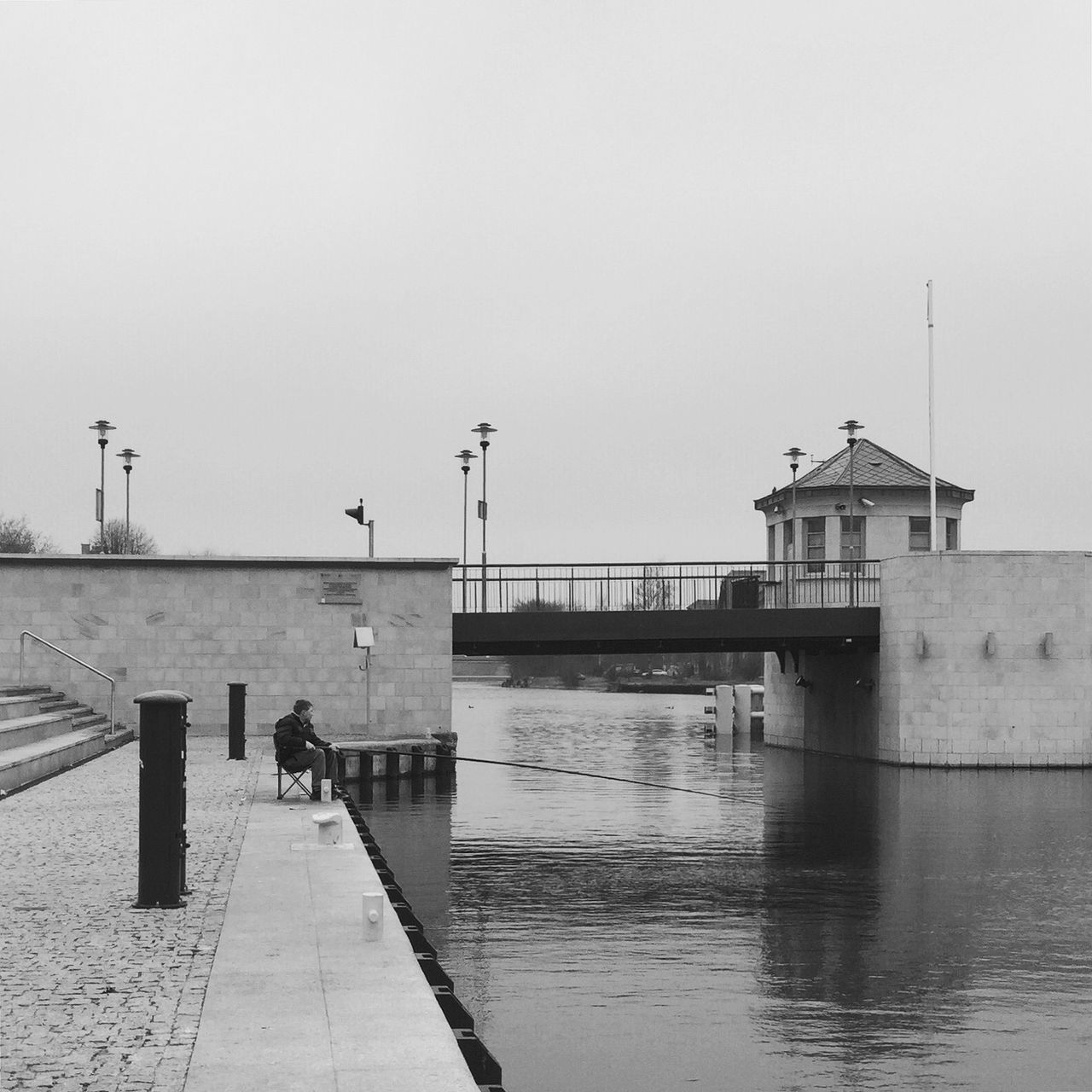 water, built structure, architecture, clear sky, pier, copy space, building exterior, men, sea, lifestyles, railing, person, walking, leisure activity, sky, street light, incidental people, outdoors, day