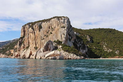 Rock formations by sea against sky