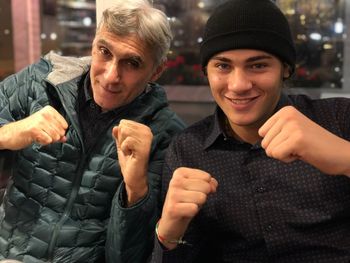 Portrait of father and son clenching fists at home