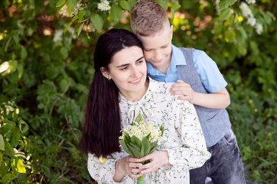 Cute boy with mom on a picnic. son hugs mom