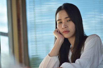 Portrait of beautiful young woman sitting at home