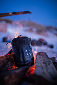 Close-up of fire on log against sky