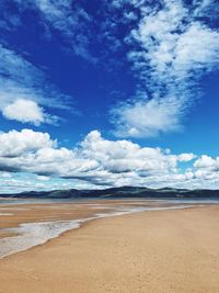 Scenic view of beach against blue sky