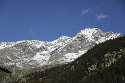 Scenic view of snowcapped mountains against blue sky