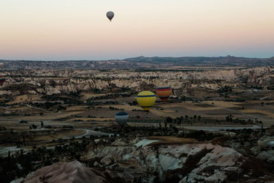 Hot air balloons flying over cappadocia during sunset