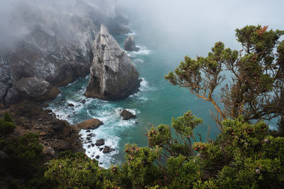 High angle view of rocks by sea against sky