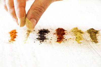 Close-up of person preparing food against white background