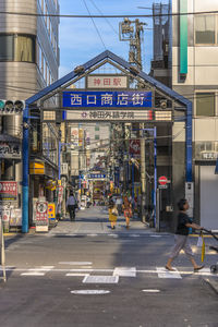 Blue metal entrance gate of the shopping street from the west exit of kanda station.