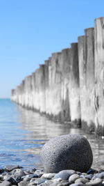 Rocks on beach against clear sky