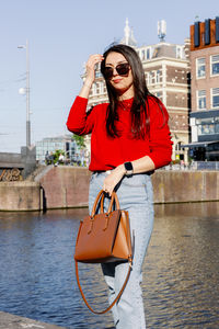 Full length of young woman standing in boat