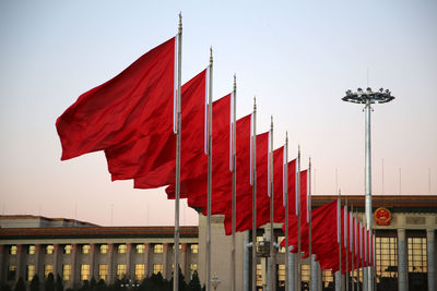Low angle view of red flags against clear sky