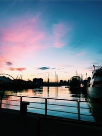 Boats moored at harbor during sunset