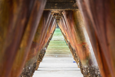 Close-up of damaged columns on pier at beach