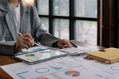 Midsection of business colleagues working on table