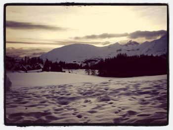 Scenic view of snow covered mountains against sky during sunset