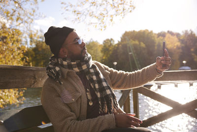 Man on bench taking selfie