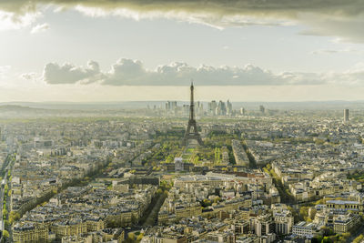 Aerial view of city buildings with eiffel tower against cloudy sky