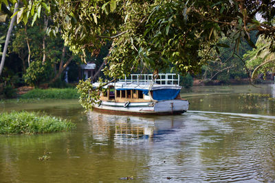 Boat moored on lake against trees