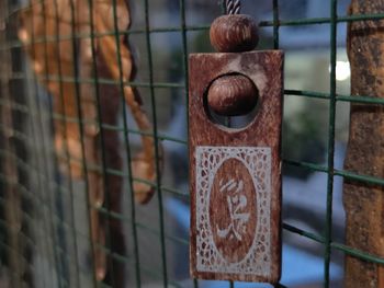 Close-up of souvenir on chainlink fence