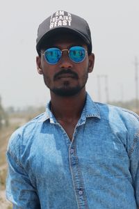 Portrait of young man wearing sunglasses standing outdoors