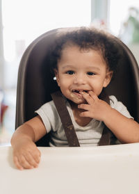 Portrait of cute baby girl sitting on table